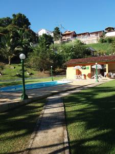 a swimming pool in a yard next to a house at Chalé em Ilhabela - Praia de Itaguassu in Ilhabela