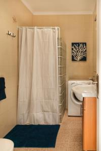 y baño con cortina de ducha y lavadora. en Apartamento Filla, en Puerto del Carmen