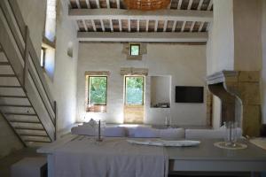 Habitación blanca con mesa y sofá en Uzes, loft dans Moulin independant 18e siecle en bord de riviere piscine privee 15x3, en Uzès