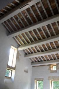 Cette chambre est dotée d'un plafond en bois et de fenêtres. dans l'établissement Uzes, loft dans Moulin independant 18e siecle en bord de riviere piscine privee 15x3, à Uzès
