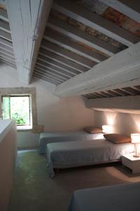 a bedroom with two beds and a window at Uzes, loft dans Moulin independant 18e siecle en bord de riviere piscine privee 15x3 in Uzès