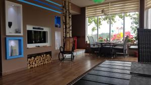 a living room with a fireplace and a dining room at Lovac Motel & Restaurant in Donji Žabar