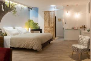 a bedroom with a bed and a chair and a door at Le Miel des Muses in Brive-la-Gaillarde +23 photos