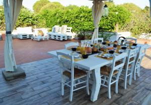 a white table and chairs on a patio at Villa Gandamar in Santa Teresa Gallura