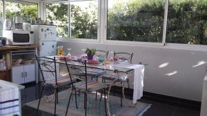 a table and chairs in a kitchen with windows at Lovely house in Cagnes-sur-Mer