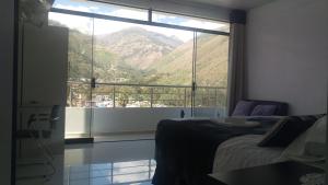 a bedroom with a large window with a mountain view at Hotel Murano in Abancay