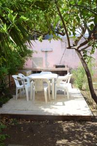 a white table and chairs sitting under a tree at Stefy Home in Catania