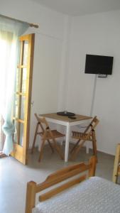 a room with a table and chairs and a television at St Paul and Peter's House in Asprovalta