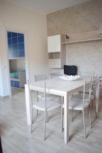 a white dining room with a white table and chairs at Stefy Home in Catania