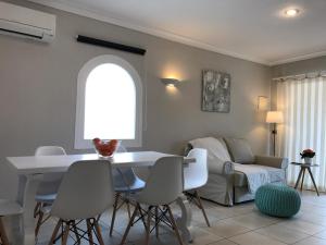 ein Wohnzimmer mit einem weißen Tisch und Stühlen in der Unterkunft Apartament Neàpolis 2 in Sant Martí d’Empúries