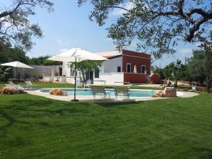 una piscina con sillas y una sombrilla en un patio en Villa Giorgia, en Monopoli