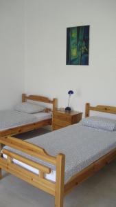 two wooden beds in a room with a picture on the wall at St Paul and Peter's House in Asprovalta