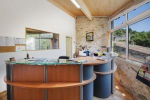 an island in the middle of a room with a large window at Le Moulin de Sournia in Sournia