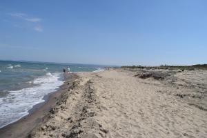 two people walking on a beach with the ocean at Stefy Home in Catania