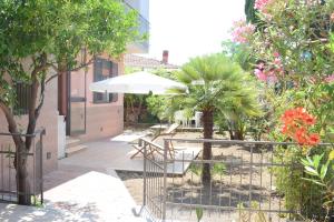 a patio with a table and an umbrella and trees at Stefy Home in Catania