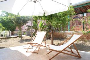 2 sillas y una sombrilla en el patio en Stefy Home en Catania