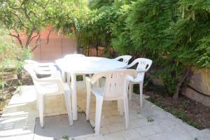 a white table and chairs in a garden at Stefy Home in Catania