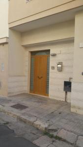 una porta marrone sul lato di un edificio di Stanza privata venus a Nardò