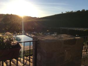 vistas a una piscina con puesta de sol en Agriturismo Borgo Umbro, en Costacciaro