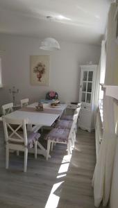 une salle à manger blanche avec une table et des bancs blancs dans l'établissement Romantic Style Apartment Berlin, à Berlin