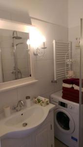 uma casa de banho com um lavatório e uma máquina de lavar roupa em Romantic Style Apartment Berlin em Berlim