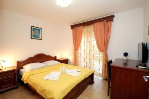 a bedroom with a yellow bed with towels on it at Apartmani More in Sveti Stefan