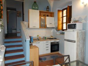 eine Küche mit einer Treppe und einem weißen Kühlschrank in der Unterkunft “La Loggia” Apartment in Casale Monferrato