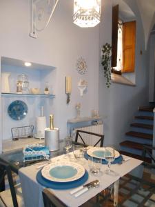 un comedor con una mesa con platos y vasos en “La Loggia” Apartment, en Casale Monferrato