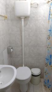 Łazienka z białą toaletą i umywalką w obiekcie Pousada Ilha Bela w mieście Paulo Afonso