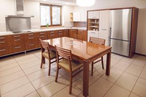 a kitchen with a wooden table and a refrigerator at Fotel in Tychy