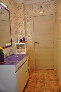a bathroom with a sink and a mirror and a door at Alenia Apartments in Alicante