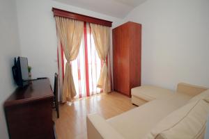 a living room with a couch and a tv at Apartmani More in Sveti Stefan