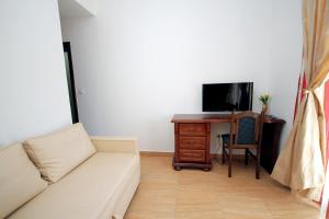 a living room with a couch and a desk with a television at Apartmani More in Sveti Stefan