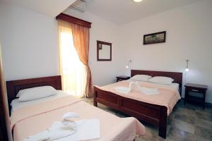 two beds in a room with swans on them at Apartmani More in Sveti Stefan