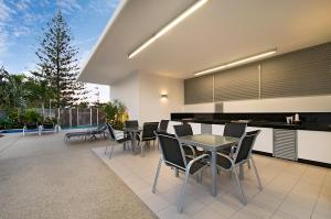 un patio con sedie e tavolo e una cucina di Ocean Pacific Resort - Official a Gold Coast