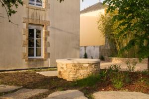 um edifício com uma fonte de pedra em frente a um edifício em Le Puy Carmin - Gîte 6 personnes - 18 min du PuyDuFou em Bazoges-en-Paillers