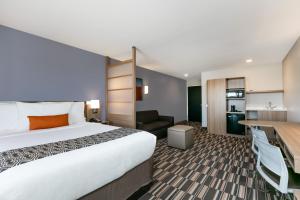 莫纳汉斯Permian Studio Apartments的配有床和书桌的酒店房间