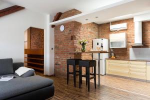 ブルノにあるOld Town Apartment Spilberkのレンガの壁のリビングルームとキッチンが備わります。