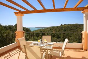 a table and chairs on a balcony with a view at The View – Santo António Villas, Golf & Spa in Salema