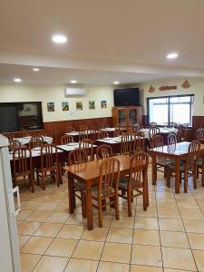 ein Esszimmer mit Holztischen und -stühlen in der Unterkunft Guest House Sabores da Beira in Castro Marim