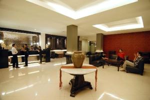 a lobby with a vase on a table and people at Drego Hotel in Pekanbaru