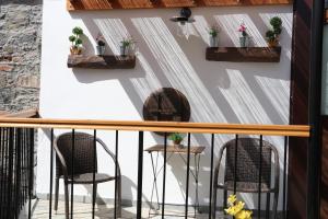 a balcony with two chairs and plants on a wall at AgroSpito Traditional Guest House in Agros