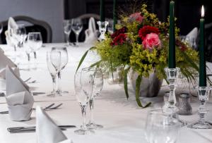 einen Tisch mit Weingläsern und eine Vase Blumen in der Unterkunft Hotel Kemper in Havixbeck