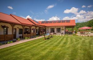 una casa con césped delante en Németh Resort, en Sovata