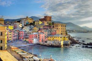 una città con edifici colorati e barche in acqua di B&B Albaro a Genova