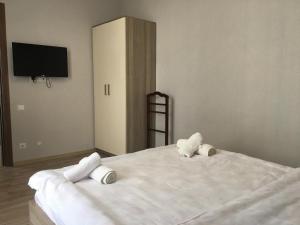 um quarto com uma grande cama branca e 2 almofadas em Apartments on Horizon em Batumi