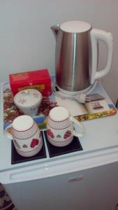 a tea pot and two cups on top of a refrigerator at I Colori del Mercato in La Spezia