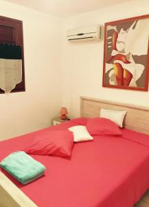 1 dormitorio con 2 almohadas rojas en una cama en Villa Kapiopa, en Sainte-Anne