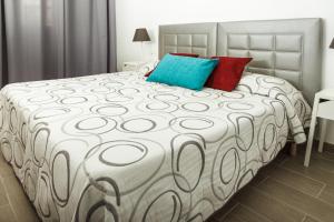 um quarto com uma cama grande com almofadas azuis e vermelhas em La Florida em Puerto del Carmen