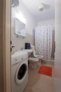 a bathroom with a washing machine and a toilet at Sunny apartment in Zadar